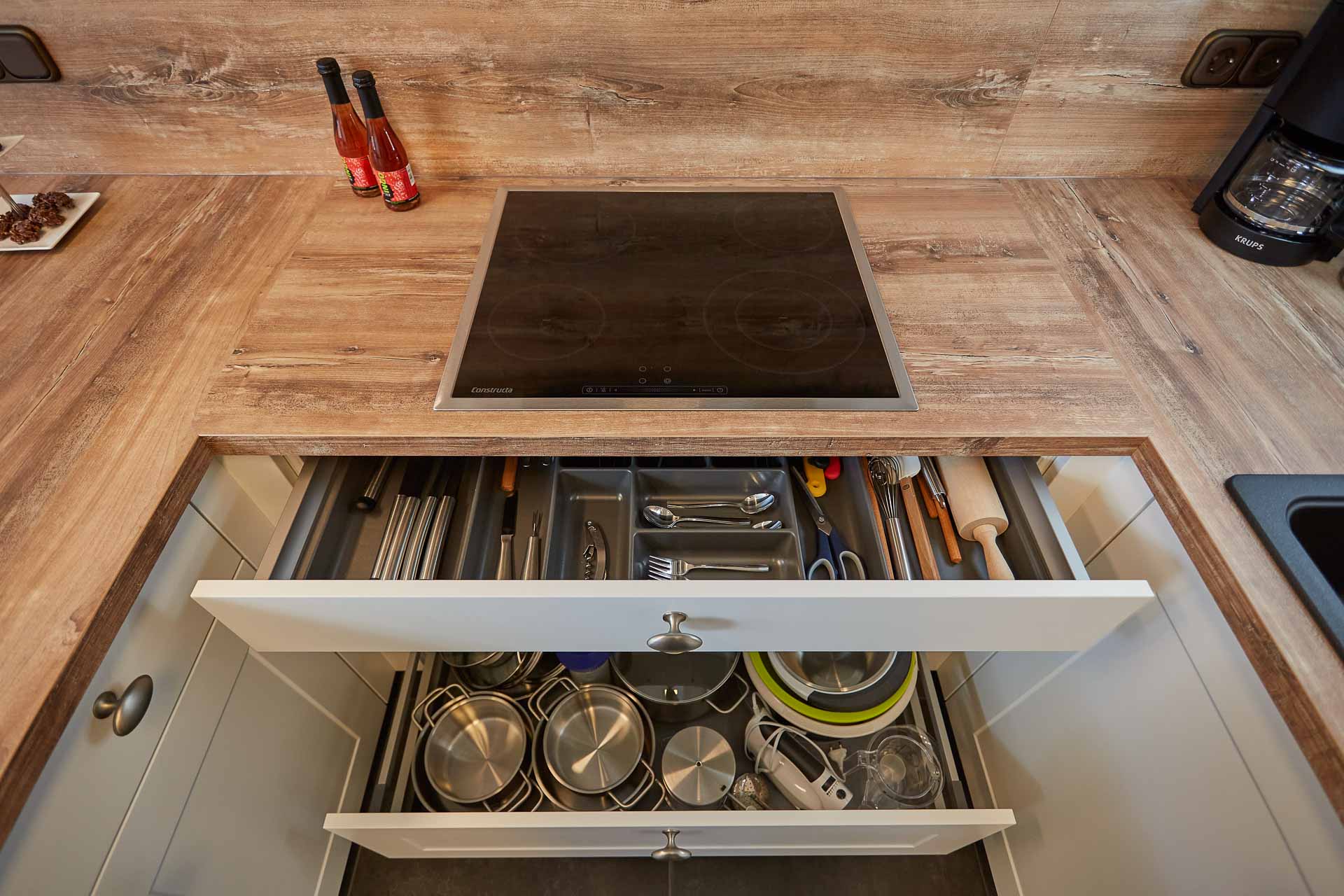 Herd und bestückte Schubladen mit Besteck und Töpfen